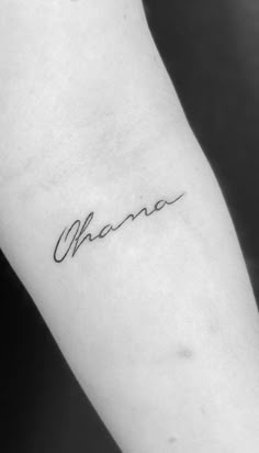 the word ohana written in cursive handwriting on the left arm