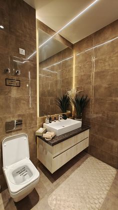 a bathroom with a toilet, sink and mirror in it's center wall area