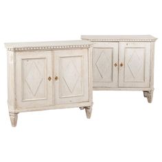 two white sideboards with diamond designs on the top and bottom, one is open