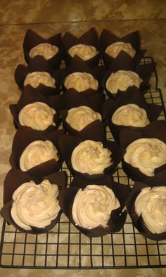 cupcakes with white frosting sitting on a cooling rack