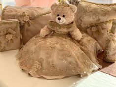 a teddy bear sitting on top of a table next to pillows and purses,