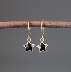 "Sweet small faceted Black Onyx stars are plated with 18k gold vermeil to create these beautiful charms. These dangle from 24k gold vermeil lever back hoops. Wonderful lightweight earrings to wear everyday. Each pair of stones will vary slightly. These earrings are also available in Blue Lapis. Onyx charms: 9x10mm (including ring at the top) Gold hoops: 1x15mm (including ring at the bottom) Total length of earrings: 1\" All gold is gold vermeil. As the owner, maker, designer, and curator of this Black And Gold Earrings Elegant, Black And Gold Earring, Dainty Black And Gold Earrings, Black Star Shaped Earrings As Gift, Black Celestial Dangle Earrings, Black Star-shaped Earrings For Pierced Ears, Black Star Charm Earrings, Black Gemstone Drop Earrings, Black Star-shaped Earrings For Party