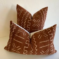 two brown and white pillows sitting on top of each other