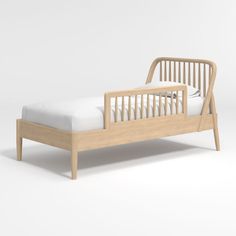 a wooden bed frame with white sheets and pillows on it, in front of a gray background