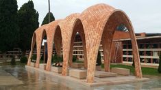 a group of arches sitting next to each other on top of a cement slab in front of a building