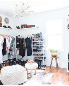 an organized closet with clothes, shoes and other items on shelves in front of a window