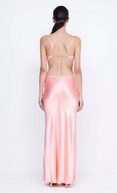 the back of a woman wearing a pink dress with spaghetti straps and an open back