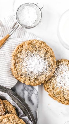 three oatmeal cookies with powdered sugar on top