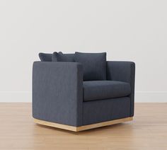 a blue chair sitting on top of a hard wood floor next to a white wall