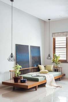 a living room filled with furniture next to two paintings on the wall and a coffee table