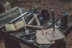 an old book is sitting on top of a wooden table with other items around it