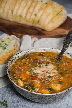 a bowl of soup with bread on the side