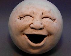 a white ceramic ball with a smiling face on it's side and its mouth open