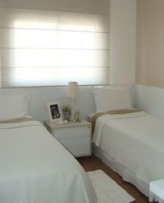 two twin beds in a small room with white walls