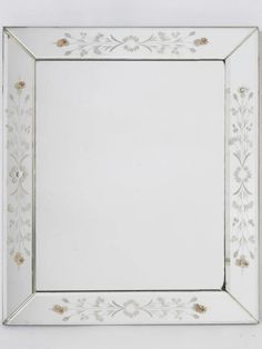 a white and silver frame with flowers on it