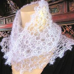 a white lace scarf on top of a mannequin