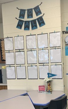 a classroom with tables and chairs in front of a bulletin board that says wow wall