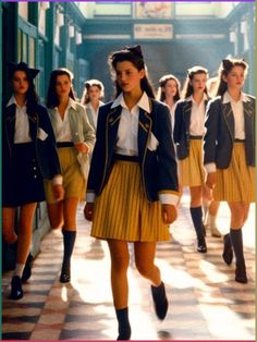 a group of girls in school uniforms walking down a hallway with their backs turned to the camera