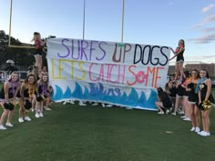 the cheerleaders are holding a sign that says surf's up dogs let's catch some