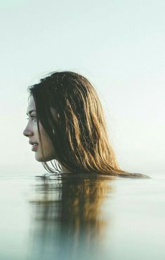 a woman with long hair is in the water