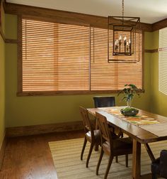 a dinning room table and chairs with blinds on the windows