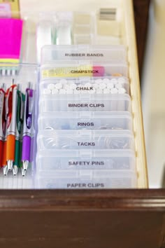 the drawers are organized with pens, markers, and other office supplies in plastic containers