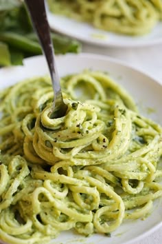 there is a fork that is in some green sauce on the plate and it is ready to be eaten