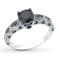 a black and white diamond engagement ring on a white background with the center stone surrounded by diamonds