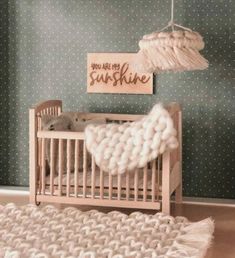 a baby crib in a room with polka dot wallpaper and a wooden sign that says you are the sunshine