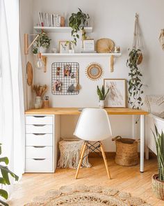 a white desk and chair in a small room with lots of plants on the wall