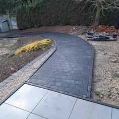 a paved walkway in the middle of a garden