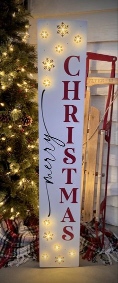 a wooden sign that says christmas with lights on it