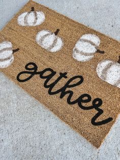 a door mat that says gather with pumpkins on it