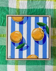 a painting of three lemons on a blue and green checkered tablecloth