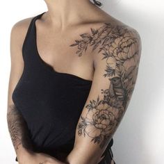 a woman with tattoos on her arm and shoulder