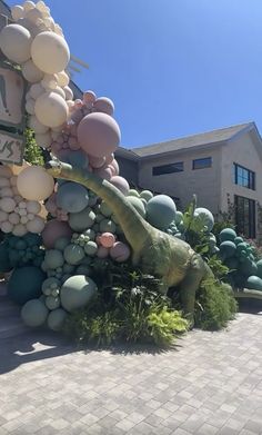 a large display of balloons and dinosaurs in front of a building