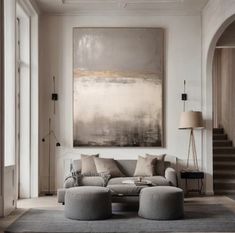 a living room filled with furniture and a painting on the wall