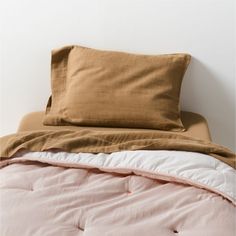 an unmade bed with two pillows on it