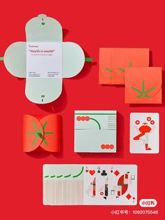 an assortment of cards and envelopes are arranged on a red surface with green lines