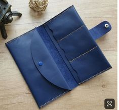 a blue leather wallet sitting on top of a wooden table