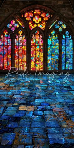 a large stained glass window sitting inside of a building next to a stone floor covered in blue and red tiles