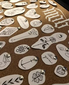 many different types of stickers are on the table with some metal tacks attached to them