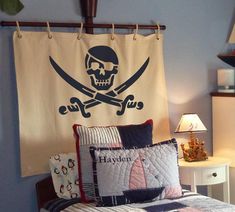 a bedroom with a pirate themed wall hanging above the bed and pillows on the headboard