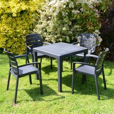 an outdoor table and chairs in the grass