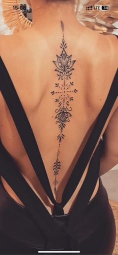 the back of a woman's neck with tattoos on her upper and lower back