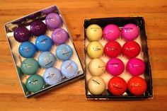 two boxes filled with different colored golf balls on top of a wooden table next to each other