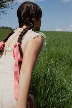 a woman with braids standing in tall grass