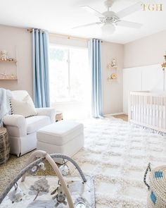 a baby's room with white furniture and blue curtains