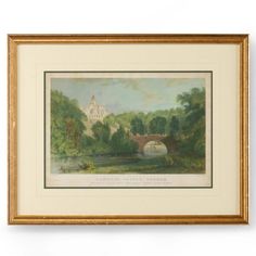 a painting hanging on the wall next to a white wall with a gold frame and an image of a bridge over a river