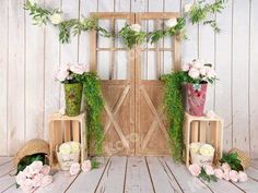 an arrangement of flowers and greenery on display in front of a wooden door,